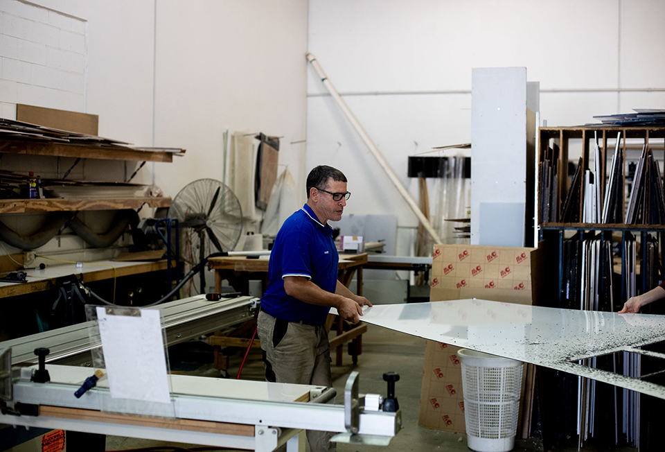 Worker measuring acrylic sheet for cutting